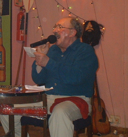 Gordon Cragg seated at rickerty bingo table reading a note and sweating profusely